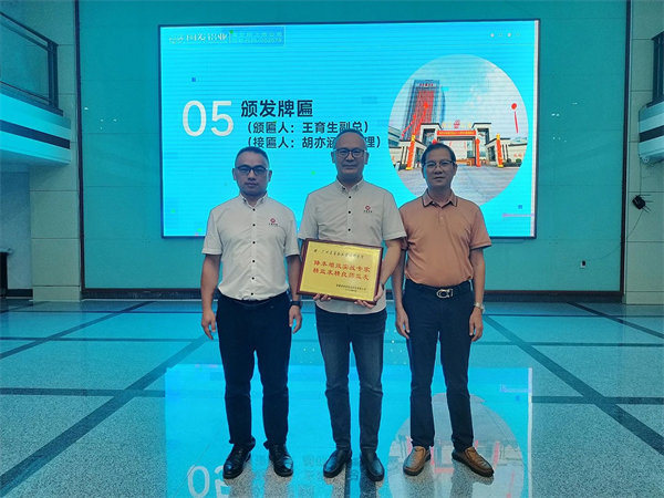 闽发铝业生产中心副总经理王育生先生（右）向优米体育限时特惠颁发牌匾